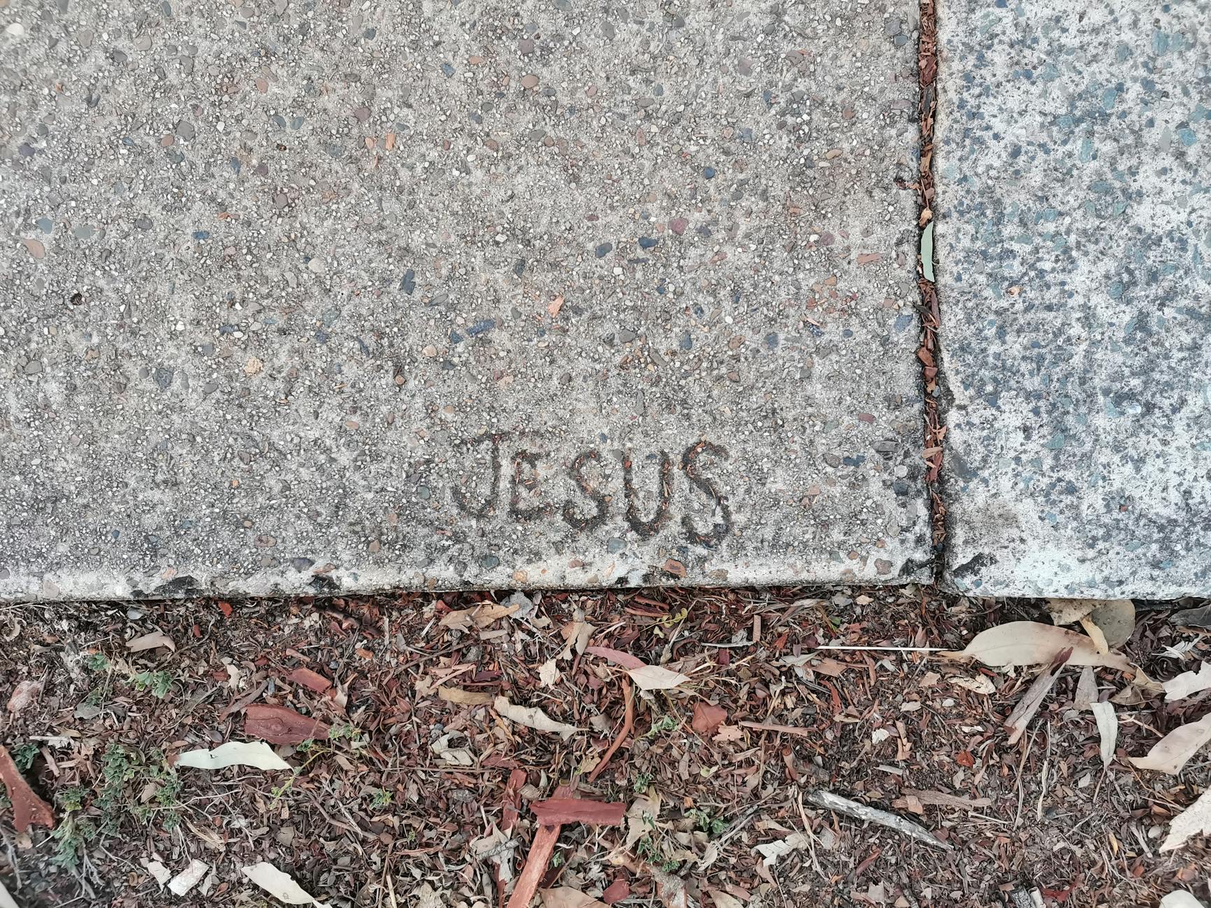 jesus name engraved on concrete surface